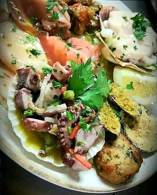 Antipasto di mare de L'Antico Podere: polpo in conchiglia, salmone, cozze gratinate, polpetta di pesce e limone